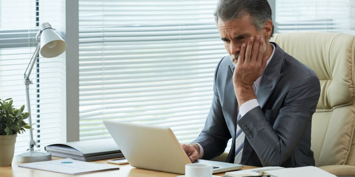 A boss at his desk concerned about his business' data privacy.