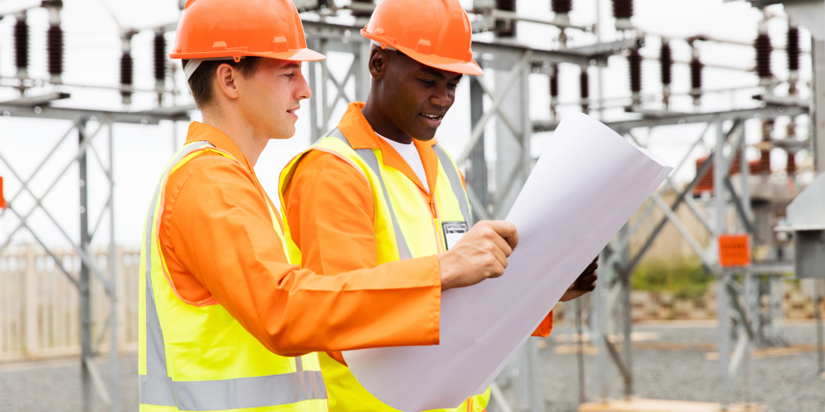 Two construction workers on a job site discussing the blueprints that were printed using wide format printing.