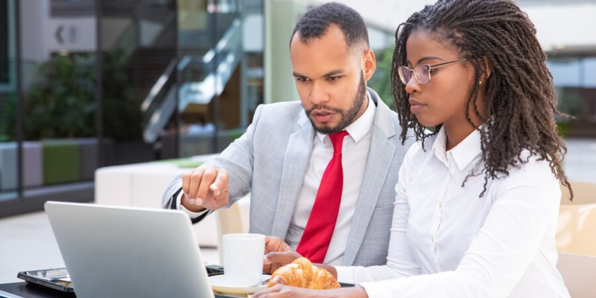 Two co-workers review their data privacy on a laptop.